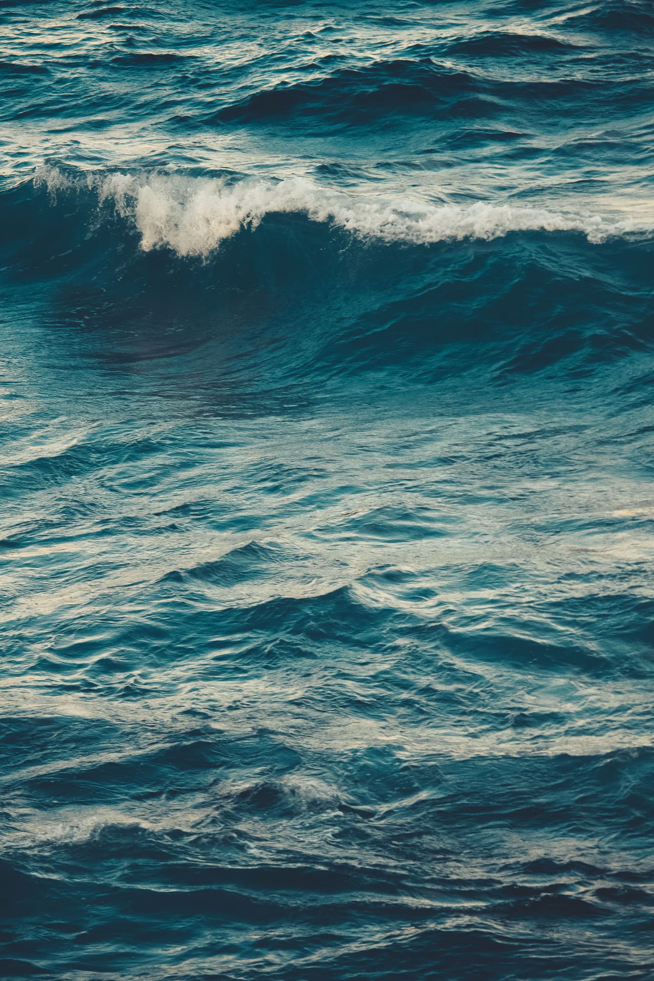 Côte bretonne sauvage, vagues et lumière terracotta à l'horizon